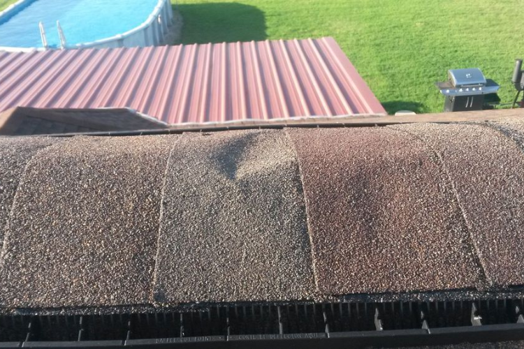 Technicians assessing storm damage on a roof in Grand Saline.